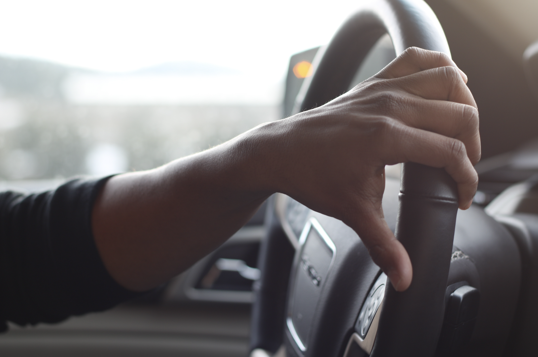 man's hand on steering wheel