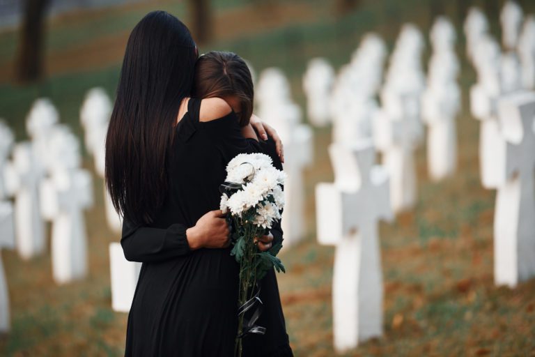 women in graveyard crying