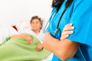 Nurse with folded arms looking over old person