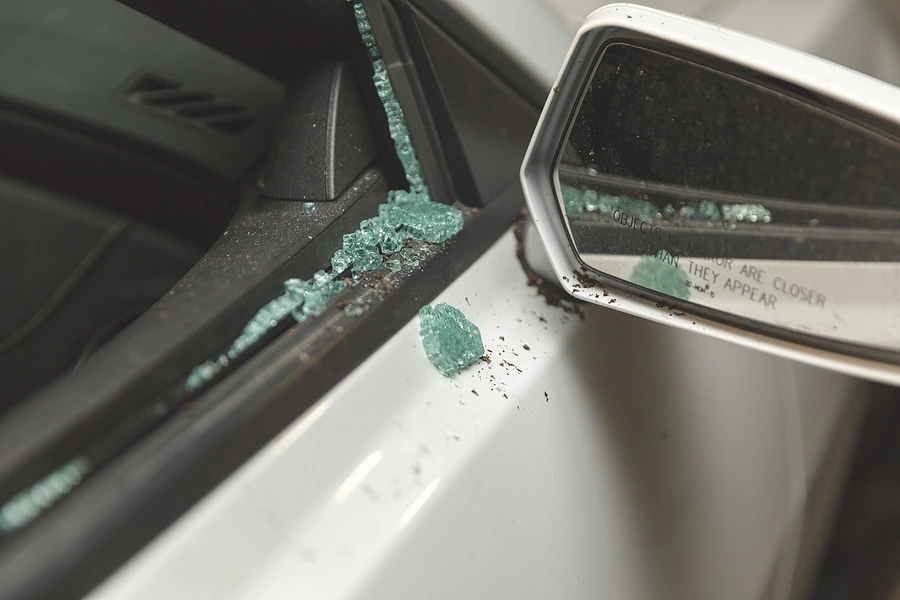 Ventana de coche rota simbolizando brechas de seguridad